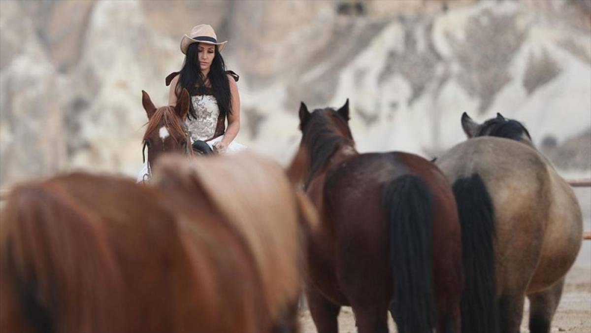 Turistler, Kapadokya'da tarihi kostümlerle at üstünde objektif karşısına geçiyor